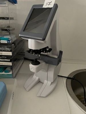 a microscope that is sitting on a counter next to a sink