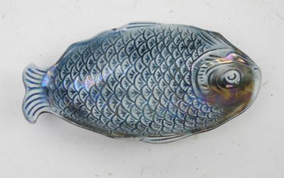 a small blue fish shaped object on a white surface