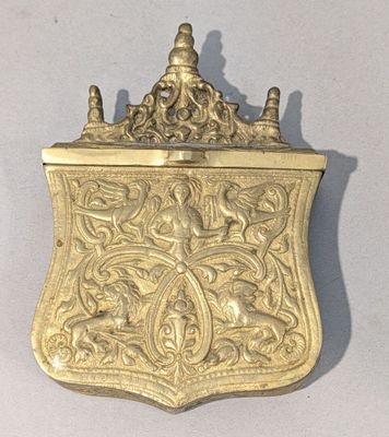 une assiette ancienne en or sur laquelle est représenté un oiseau