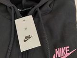 a close up of a black hoodie with a pink nike logo on it