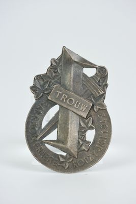 une vieille pièce d'argent entourée d'un ruban, posée sur un fond blanc