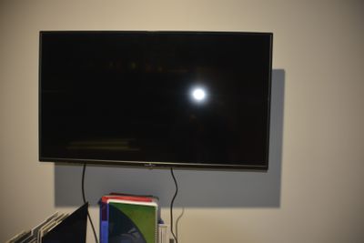 a flat screen tv mounted on a wall above a desk
