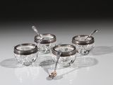 quatre tasses plaquées argent avec leurs cuillères, posées sur un fond blanc