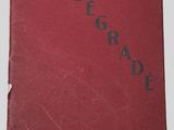 un livre rouge posé sur une table à côté d'un mur blanc