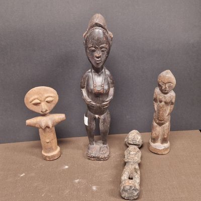 trois statues en bois de formes et de tailles différentes posées sur une table