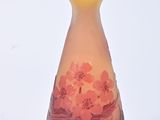 a glass vase with flowers on it on a white surface