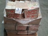 une pile de cartons posée sur une palette, sur laquelle est accrochée une pancarte