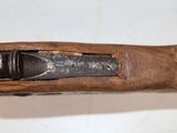an old gun with a wooden handle on a white surface
