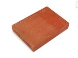 an old book with a red cover sitting on top of a white surface