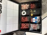 une boîte noire posée par terre et remplie d’objets divers