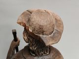 statue of a man with a hat and a cane on a white background