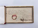 an old book with a ring on top of it