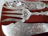 quatre pièces d'argenterie sur un tissu rouge sur une table
