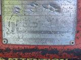 an image of a metal sign on a red machine