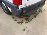 a white truck parked in a parking lot with dirt on the ground