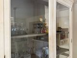 a cabinet with many glasses on it in the kitchen
