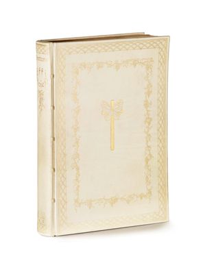 an old book with a cross on it sitting on a white surface