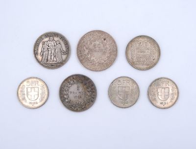 six different british coins are arranged in a row on a white surface
