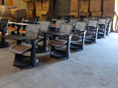 des rangées de chaises dans un entrepôt, sur lesquelles sont empilées des cartons