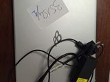 a laptop with a cord attached to it with a note attached to it