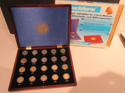 une boîte de pièces d'argent posée sur une table à côté d'une boîte de pièces d'or