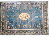 un vieux tapis bleu orné d'un motif floral