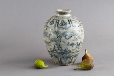 un vase bleu et blanc, avec deux poires à côté