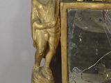 a gold clock with a boy on it and a mirror