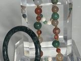 deux bracelets et une bague présentés sur un présentoir transparent