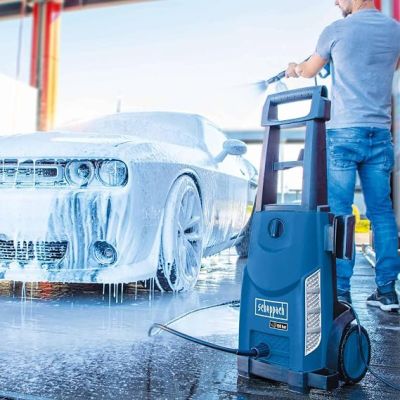 un homme en train de laver une voiture avec un nettoyeur haute pression