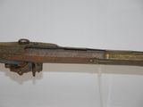 an old gun with a wooden handle on a white surface