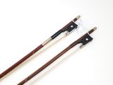 two wooden violin bows on a white surface with a white background