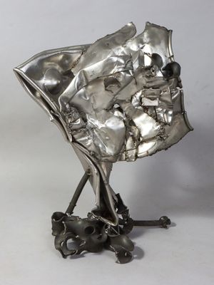 silver sculpture of a baby in a stroller on a metal stand
