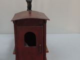 a small wooden train car with a cat sitting on top of it