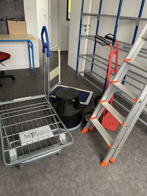 plusieurs échelles et une table dans une pièce où se trouvent un bureau et une chaise