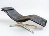 une chaise longue en cuir noir posée sur un piètement en métal