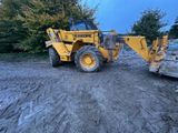 une photo d'un engin de chantier garé sur un chemin de terre