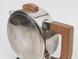 a silver teapot with a wooden handle on a stand