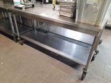 a large stainless steel table with a bunch of plates on it