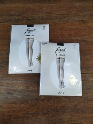 Deux paires de collants blancs sont posées sur un parquet.