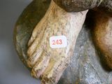 un gros plan sur la statue d'une personne dont le pied repose sur un rocher