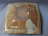 a brown plate with a leaf on it on a table