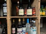many bottles of alcohol sitting on a wooden shelf