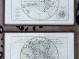 two framed maps of the world on display in a wooden frame