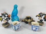 un oiseau bleu perché sur un vase, à côté d'autres vases