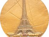 an image of a gold medal with the eiffel tower on it