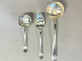 three silver spoons and a silver spoon on a white surface