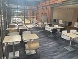 many tables and chairs in a room with a lot of windows