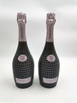 deux bouteilles de champagne posées l'une à côté de l'autre sur une surface blanche
