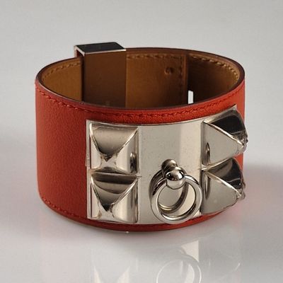 un bracelet en cuir rouge orné de clous argentés